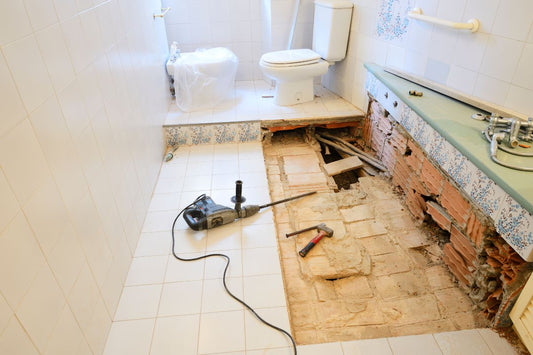 a typical bathroom demolition scene with tiles being removed from the floor